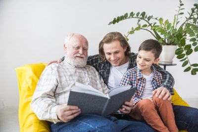 familia-multigeneracional-mirando-traves-antiguo-album-fotos_23-2148114385