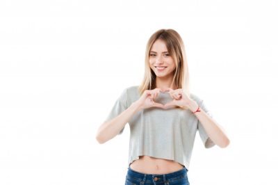 mujer-joven-bastante-sonriente-que-muestra-gesto-corazon-dos-manos_171337-18109