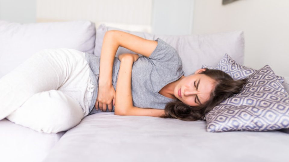 mujer-joven-dolor-abdominal-debido-menstruacion-acostada-sofa-sosteniendo-su-estomago_231208-689